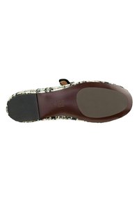 Sole a righe in bianco e nero con una base in gomma marrone liscia; presenta una parte superiore intrecciata con tonalità terrose e una fascia decorativa.
