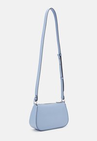 Ljusblå läderväska med axelrem i korsformat, elegant rundad form, justerbar rem och silverdetaljer. Slät textur och minimalistisk design.