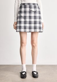 Μαύρη και λευκή καρό φούστα με φαρδιά σιλουέτα, διαθέτει πίσω τσέπη, υφασμάτινης υφής και αντίθετη ζώνη. 