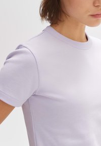 Lila kortef tshirt met ronde hals, gemaakt van soepele stof. Heeft een getailleerd design en subtiele stiksels bij de naden.