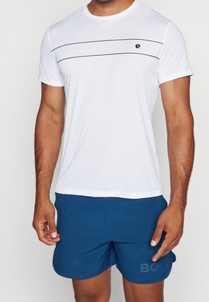 Camiseta atlética blanca con rayas horizontales negras en el pecho, combinada con pantalones cortos azules que presentan un logo sutil en la tela.