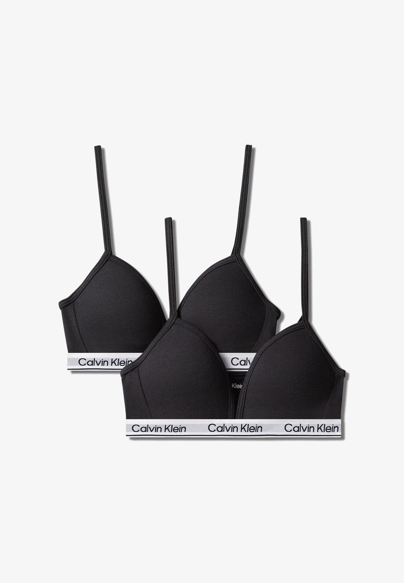 Trois soutiens-gorge triangle noirs Calvin Klein avec des bretelles fines et des bandes élastiques blanches affichant le nom de la marque.
