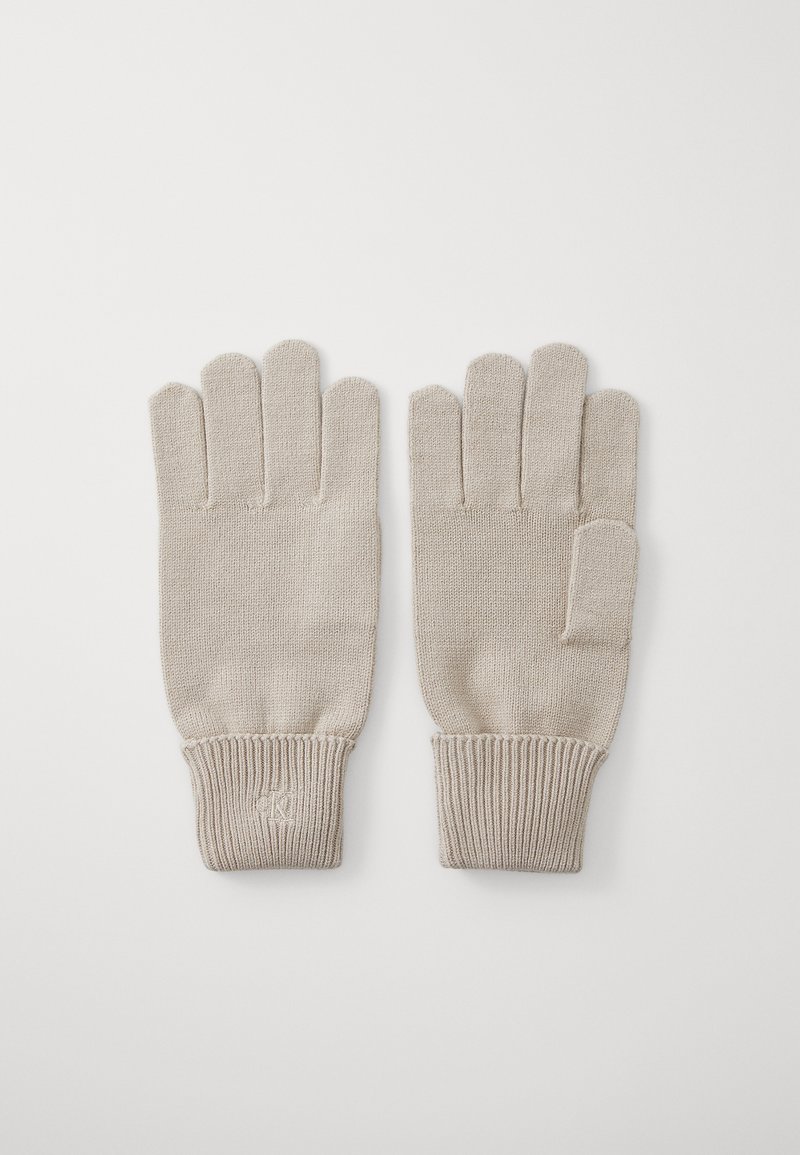 Gants en tricot beige avec des poignets côtelés, design à cinq doigts et un petit accent au poignet. Texture douce, adaptée aux temps froids.
