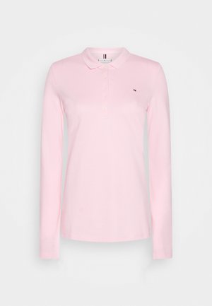 Polo rose clair à manches longues avec col et patte de boutonnage, avec un petit logo brodé sur la poitrine gauche.