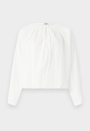 Weiße langärmelige Bluse mit rundem Ausschnitt und plissierter Textur. Leichter Stoff mit lockerer Passform und sanft gerafftem Detail an der Vorderseite.