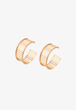 Guldtonede metal hoops øreringe med et åbent design, der har lodrette udskæringer og en snoet kant detalje.