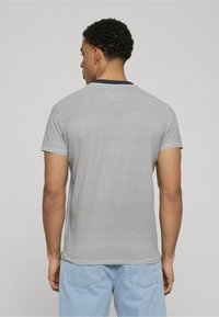 Camiseta de manga corta a rayas en gris y azul marino, con un cuello redondo y un corte relajado, hecha de una suave tela de mezcla de algodón.