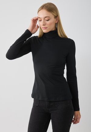 Melna gara piedurkne turtlenecka blūze, kas izgatavota no mīkstas auduma. Pieguļošs dizains ar gludu tekstūru un viļņotu apakšmalu.