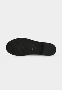 Semelle de chaussure noire avec des rainures horizontales sur la moitié avant, talon lisse, marquée "Made in Italy" et taille "37" au centre.