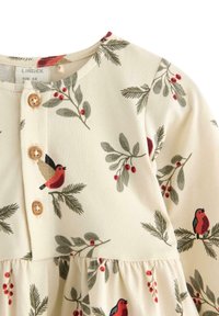 Ein hellfarbiges Baumwolkleid mit rundem Ausschnitt, Holzknopfverschluss und einem Druck von roten Vögeln und grünem Laub. Besondere Rüschendetails am Saum.