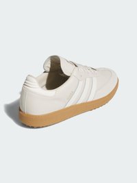 Białe skórzane sneakersy z trzema jasnoniebieskimi paskami, gumową podeszwą i teksturowaną brązową podeszwą. Posiadają wyściełany język oraz sznurowany design.