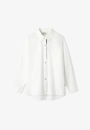 Chemise blanche à manches longues avec un col pointu, fermeture à boutons et coupe ample. Fabriquée en tissu léger avec un léger brillant.