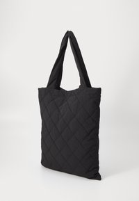 Czarna torebka tote w pikowanym wzorze diamentów, wykonana z lekkiego materiału. Posiada długie, mocne uchwyty oraz miękką, teksturowaną powierzchnię.