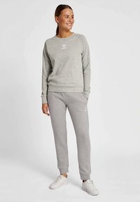 Szara bawełniana bluza z okrągłym dekoltem i logo, zestawiona z pasującymi szarymi spodniami dresowymi z elastycznymi ściągaczami i detalem z logo.