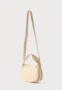 Beige leren crossbodytas met verstelbare band, gouden metalen onderdelen en een afgeronde onderkant tegen een effen witte achtergrond.