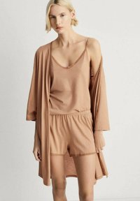Vaateyhdistelmä, jossa on vaaleanruskea loungewear-setti, kainalotoppi, jossa on pitsireunus, yhteensopivat shortsit joustavalla vyötäröllä sekä avonainen kimono-tyylinen viitta.