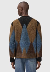 Πλεκτό πουλόβερ σε καφέ, μπλε και μαύρο με γεωμετρικά διαμάντια. Διαθέτει στρογγυλή λαιμόκοψη και ριμπ μανσέτες. Μαλακό, υφασμένο ύφασμα.