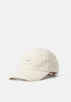 Casquette de baseball en polaire sherpa blanche avec patch logo Calvin Klein à l'avant, visière incurvée et sangle de réglage à l'arrière.
