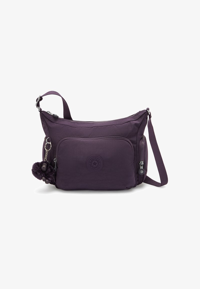 Borsa a tracolla in poliestere viola con una texture morbida, dotata di una tasca con zip sul davanti, un'etichetta con logo e un portachiavi con pom-pom decorativo.