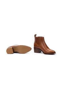 Bottines en cuir marron avec un bout pointu et un talon bloc, dotées de panneaux en élasthanne sur les côtés et d'une languette à l'arrière. Texture lisse.