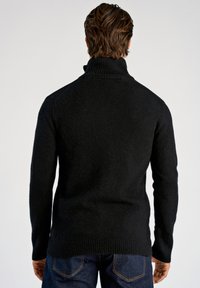 Schwarzer Strickpullover mit hohem Kragen, gerippten Bündchen und Bund. Weiche Textur, schlichtes Design, Ansicht von hinten.