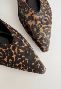 Leopardmønstret flade sko med spids tå lavet af tekstureret hård skjul, med sort inderside og en slank, spidset silhuet.