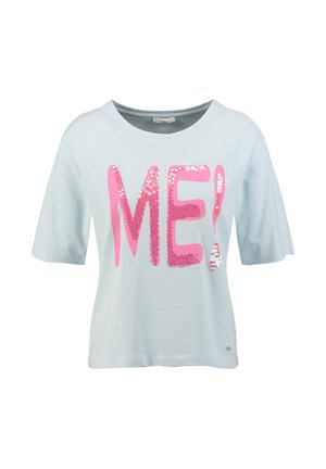 Jasnoniebieska koszulka z krótkim rękawem z dużymi różowymi cekinowymi literami tworzącymi słowo „ME!” na przodzie, okrągły dekolt, luźny fason.