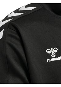 Zwarte sporttop met een gladde structuur, voorzien van witte chevronpatronen op de schouder en een wit logo op de borst.