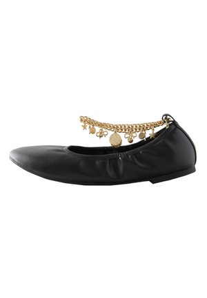 Zwarte ballerina platte schoen met elastische opening en gouden ketting enkelband met ster-, munt- en bloembedels.