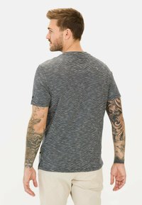 Męska szara koszulka z krótkim rękawem w teksturowany, prążkowany wzór. Posiada okrągły dekolt i widoczne szwy.