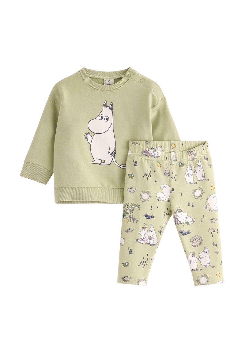 Vihreä kaksiosainen asu, joka sisältää hupparin, jossa on Moomin-hahmon graafinen kuvasto, ja siihen sopivat leggingsit, joissa on eri Moomin-sceneja.