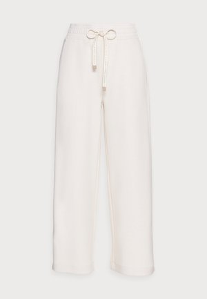 Cremfarbene weite Hosen aus weichem Stoff mit elastischem Bund und Kordelzug, ausgestattet mit seitlichen Eingrifftaschen und Fußbündchen.