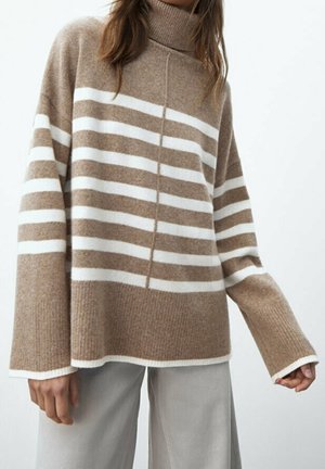 Beige og hvid stribet turtleneck sweater med lange ærmer. Blød tekstur, afslappet pasform og ribbet krave detalje. Parret med lyse bukser.