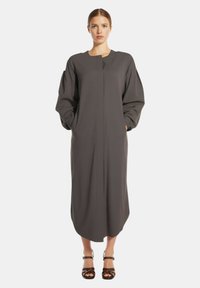 Lungo vestito grigio con un design minimalista, dotato di maniche ampie, taglio dritto e tasche laterali. Tessuto liscio con una consistenza morbida.