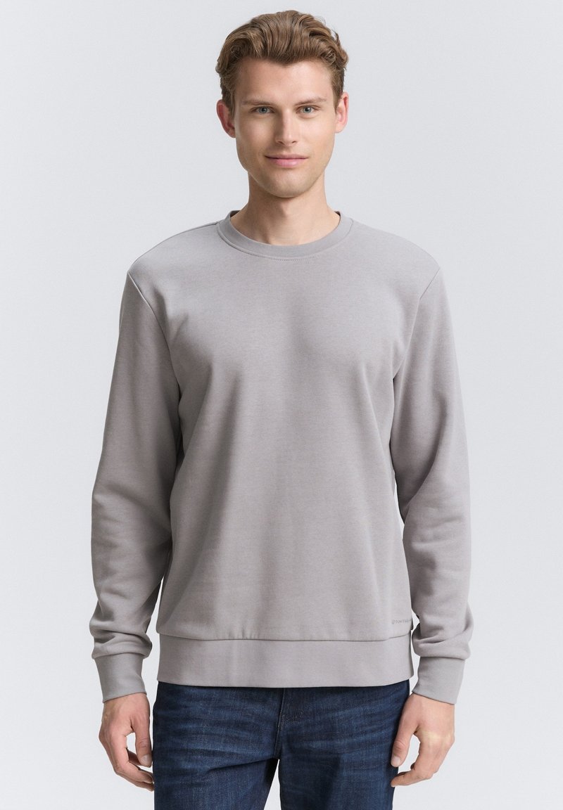 Lichtgrijze sweatshirt met ronde hals, gemaakt van zachte stof, met ribgebreide manchetten en zoom, eenvoudig ontwerp en minimale stikseldetails.