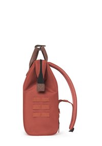 Rode stoffen rugzak met een gestructureerd oppervlak, bruine leren accenten, een ritssluiting aan de bovenkant en drie horizontale webbingbanden aan de zijkant.