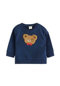 Granatowy niemowlęcy sweter z prążkowanymi mankietami, z futrzanym naszywką w kształcie twarzy misia, który ma na sobie czerwoną muszkę z przodu.