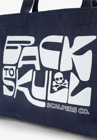 Sac en toile bleu marine avec un texte blanc audacieux "BACK TO SKULL" et un petit design de skull avec des os croisés.