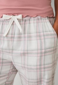 Baumwoll-Pyjama-Hosen in Weiß mit einem rosa- und graugefleckten Muster. Mit einem weißen Kordelzug und seitlichen Taschen. Scallop-Detail am Bund.