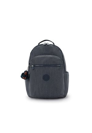 Sac à dos en tissu gris avec une forme arrondie, poche zippée à l'avant et un petit porte-clés en peluche de singe attaché. Logo visible sur le devant.
