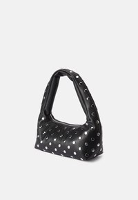 Bolsa de couro preto com uma alça arredondada, apresentando detalhes circulares metálicos e um fecho de zíper. Textura suave com um padrão de bolinhas ousado.