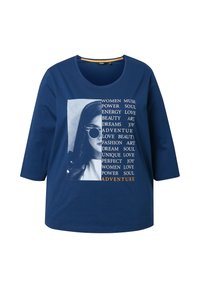 Granatowa bawełniana koszulka z okrągłym dekoltem, rękawami o długości trzech ćwiartek oraz grafiką z tekstem i czarno-białym zdjęciem kobiety.