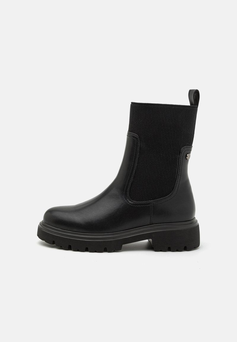 Botas de tobillo negras con un acabado de cuero suave, paneles laterales elásticos acanalados, tirador y suela de goma gruesa para una mejor tracción.