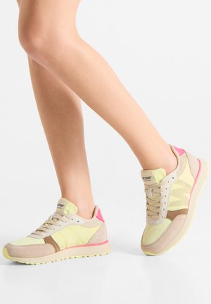 Light yellow and beige sneakers featuring mesh panels and suede accents. Pink heel tab and yellow sole. Laced design with logo on tongue.