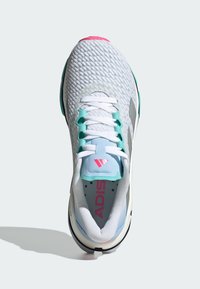 Scarpa atletica bianca con tomaia in mesh testurizzato, dettagli turchesi, tallone rosa e lacci bianchi. Presenta una soletta imbottita e un logo.