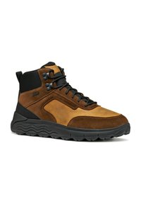 Bota de senderismo marrón y marrón claro, hecha de ante y material sintético, con cordones negros, suela de goma y acentos texturizados en los lados.