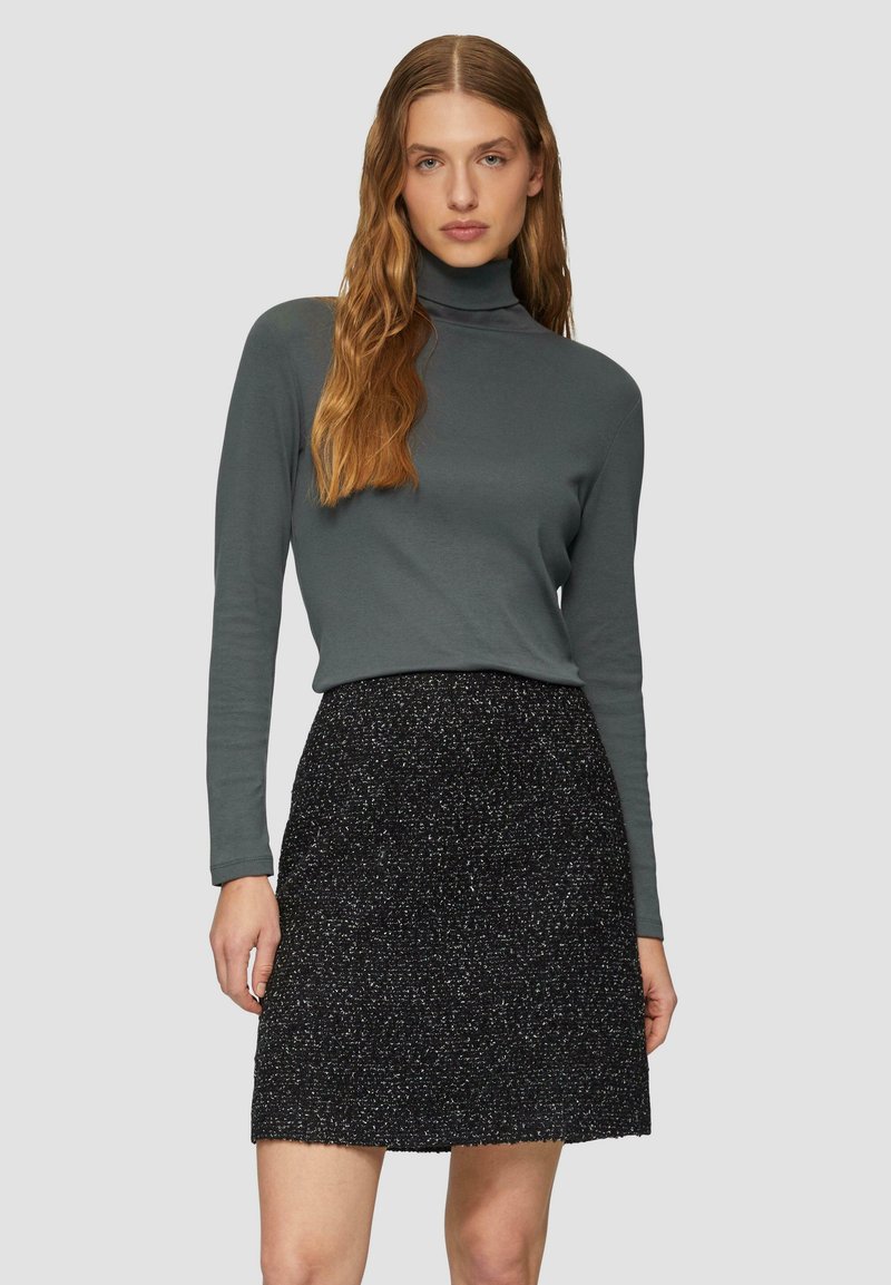 Un haut gris à col roulé associé à une jupe noire avec une finition texturée et pailletée. L'ensemble possède des manches longues et une silhouette ajustée.