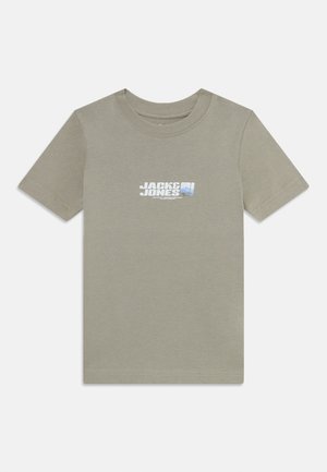 T-shirt en coton vert clair avec des manches courtes et un col rond, arborant un graphique de logo blanc et bleu sur la poitrine.
