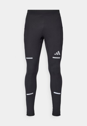 Sorte atletiske leggings med en tettsittende design, laget av elastisk materiale. Har reflekterende detaljer og glidelås på anklene for funksjonalitet.