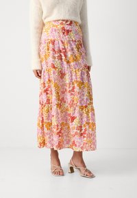 Jupe maxi florale avec un design à étages aux teintes rose, orange et jaune, fabriquée dans un tissu léger au toucher doux.